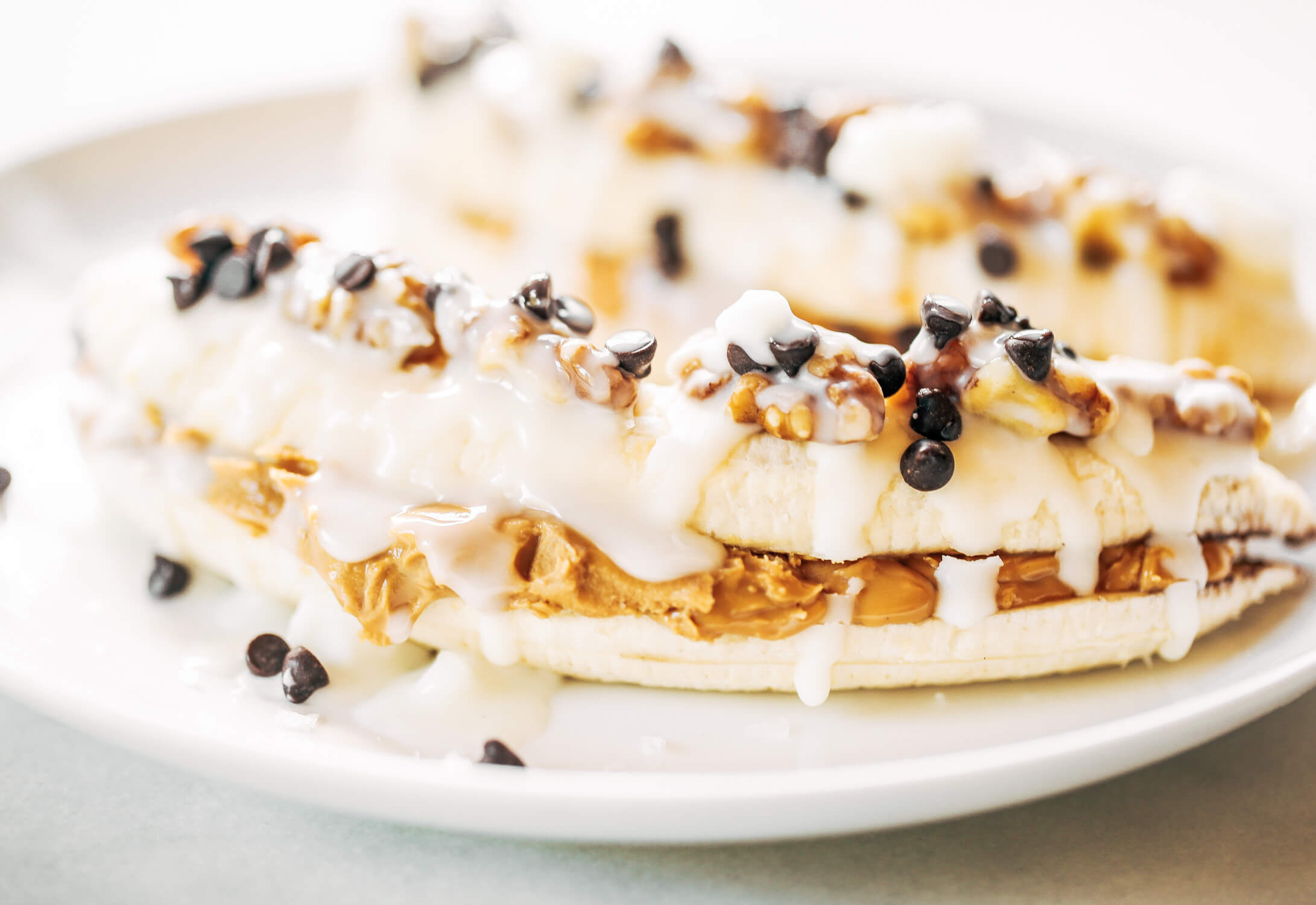 These stuffed bananas are a healthy snack idea. Made with almond butter and bananas; topped with coconut butter, mini chocolate chips, and sea salt flakes. Make this easy paleo diet snack for breakfast for after dinner treat. Paleo diet fro beginners. Paleo diet snack recipes. Paleo breakfast recipes. Whole30 meal prep snacks. Easy whole30 breakfast recipes. #paleo #healthysnack #whole30