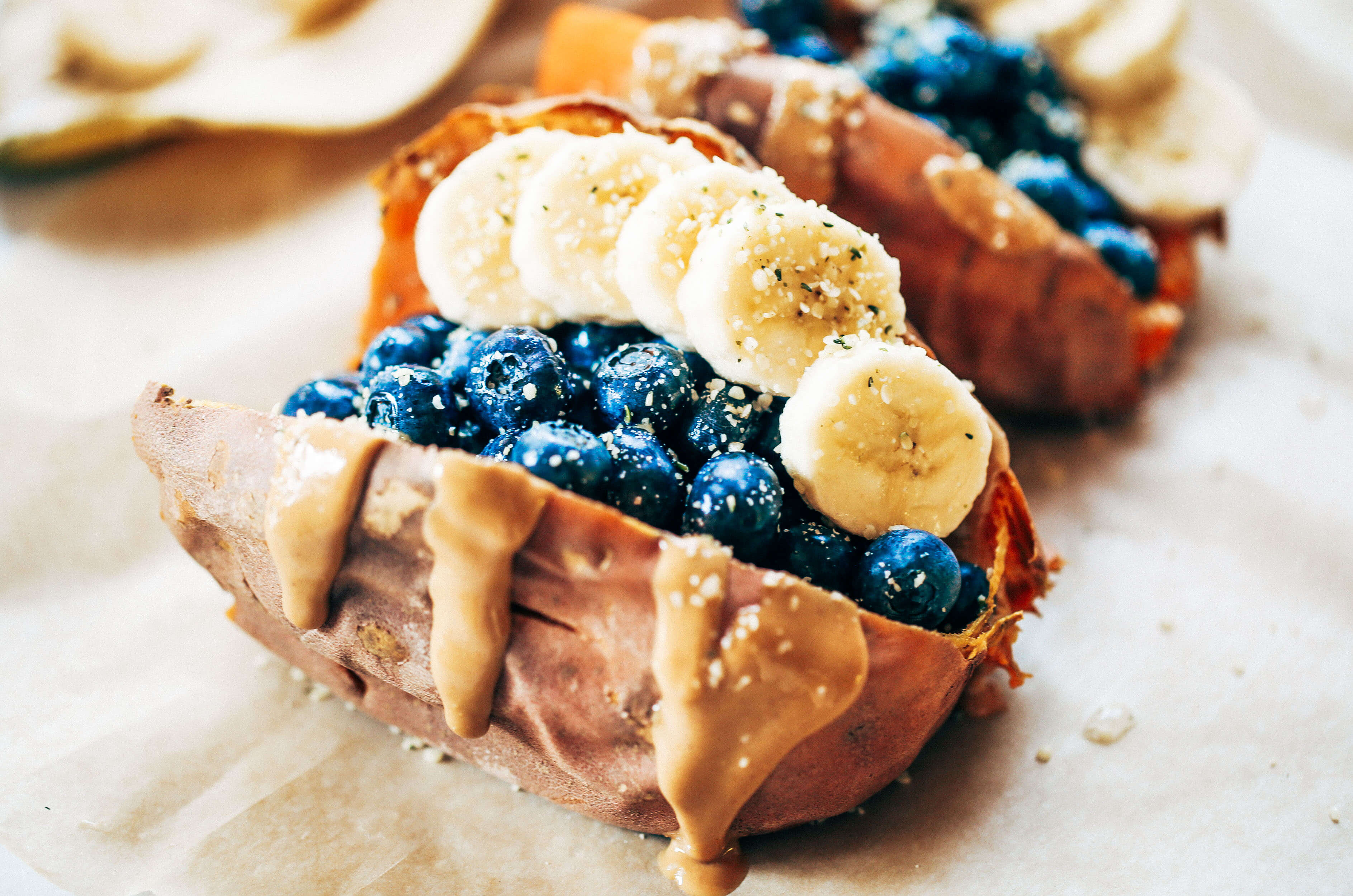 Baked sweet potatoes stuffed with blueberries, bananas, and cashew butter make a tasty whole30 vegan breakfast! You can make them ahead of time for whole30 meal prep. This easy paleo breakfast makes a great snack anytime of day! #paleo #mealprep #whole30 #vegan