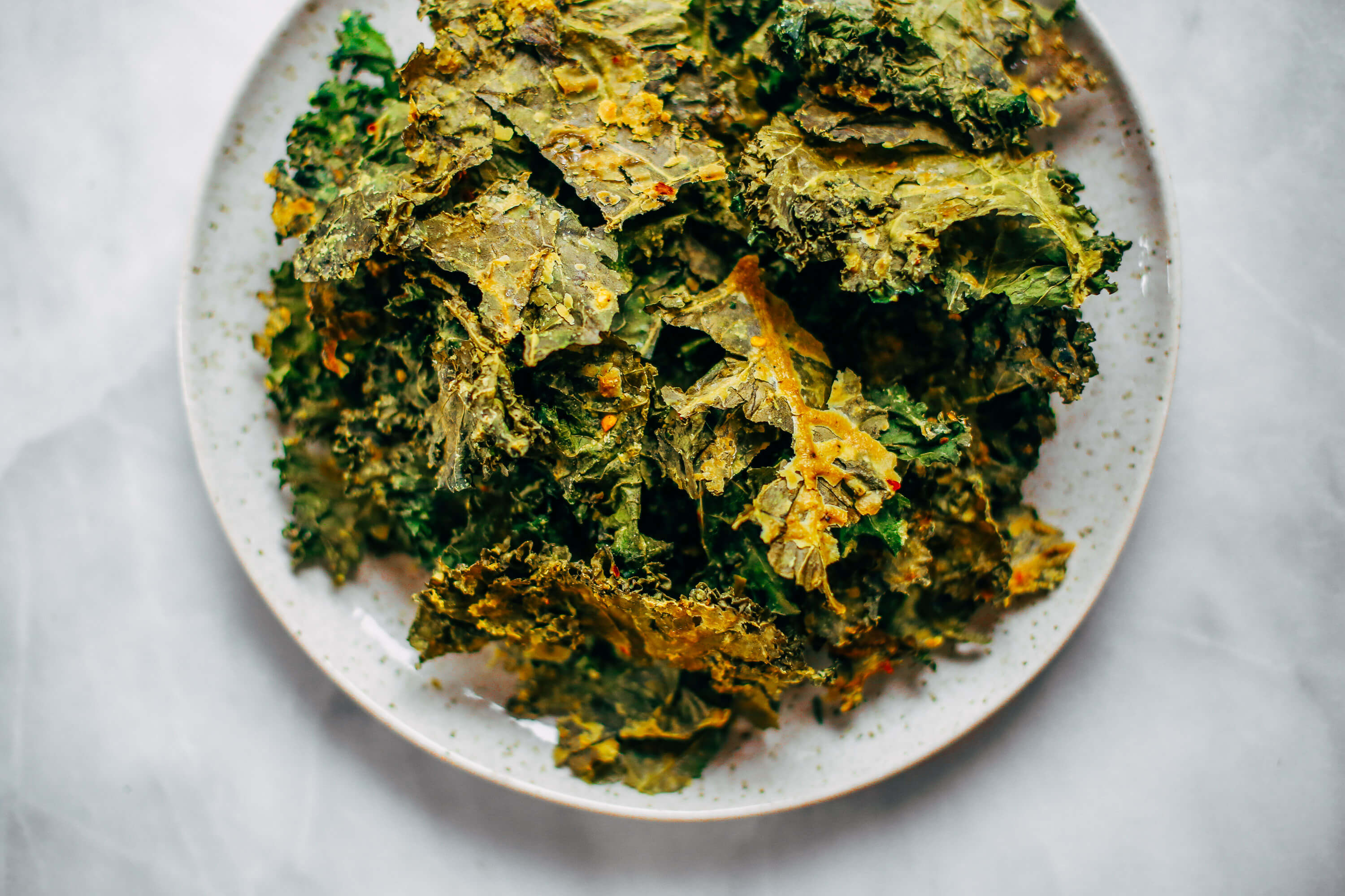 Zesty lemon garlic kale chips. Homemade kale chip recipe. Easy whole30 snack for on the go. These healthy paleo kale chips are made with just a few ingredients and are SO easy to make! #whole30 #paleo #vegan #recipe #cooking