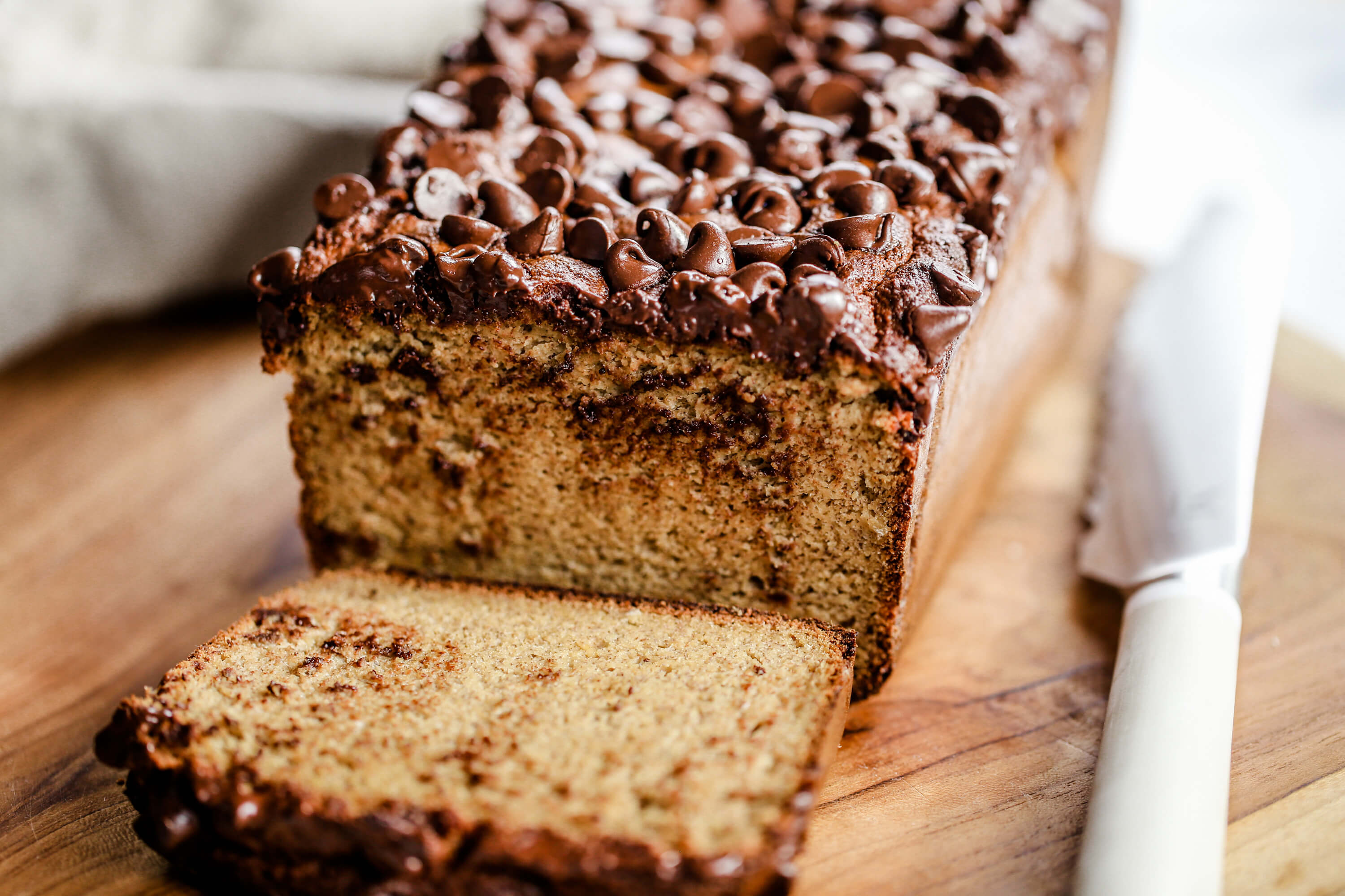 Healthy banana bread recipe made in just 5 minutes! This easy paleo gluten free banana bread has a secret healthy ingredient: cauliflower! No one ever tastes it though- and all the wheat eaters love this delicious banana bread.
