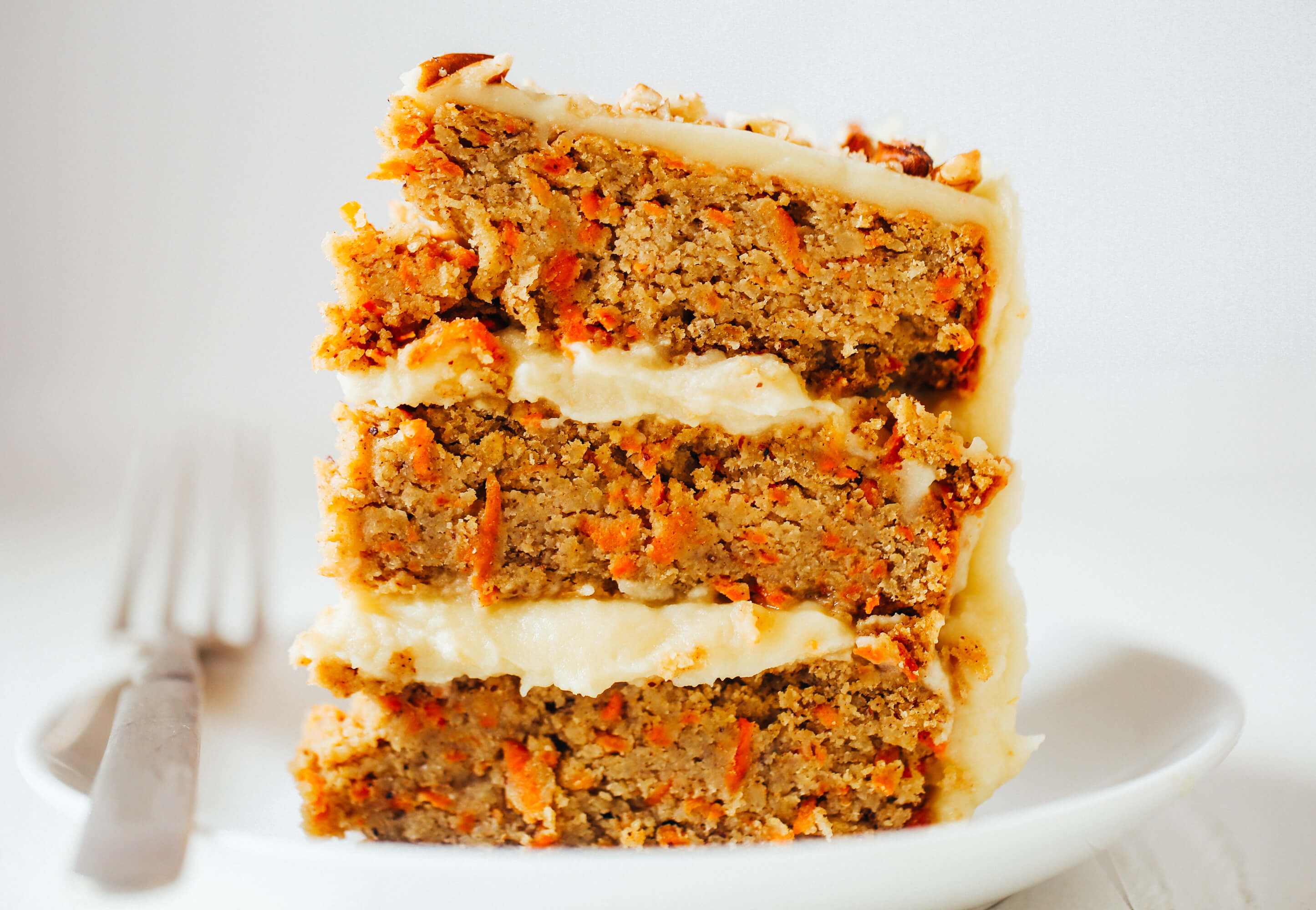 Paleo carrot cake made with sweet potatoes. Topped with creamy lemon frosting made from white sweet potatoes. A healthy carrot cake recipe that is gluten free and dairy free. Moist and flavorful carrot cake perfect for spring! #cake #baking #paleo #recipes